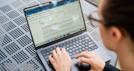 A person sitting at a table with their laptop looking at the MIT Learn platform.