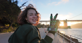 Candid photo of a teenager wearing an electronic glove outside during sunset.