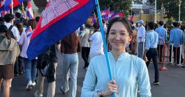 Sok Danica smiles while holding a flag