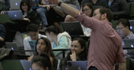 Instructor appears to be standing amongst students in a lecture hall while teaching