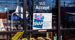 store window with sign about accepting snap