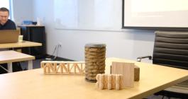 Photo of a table with four wooden structures sitting on top.