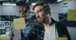 two people writing on a board
