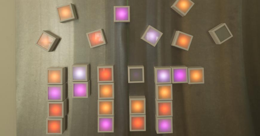 Photo of light blocks arranged to spell "MIT" on a table.
