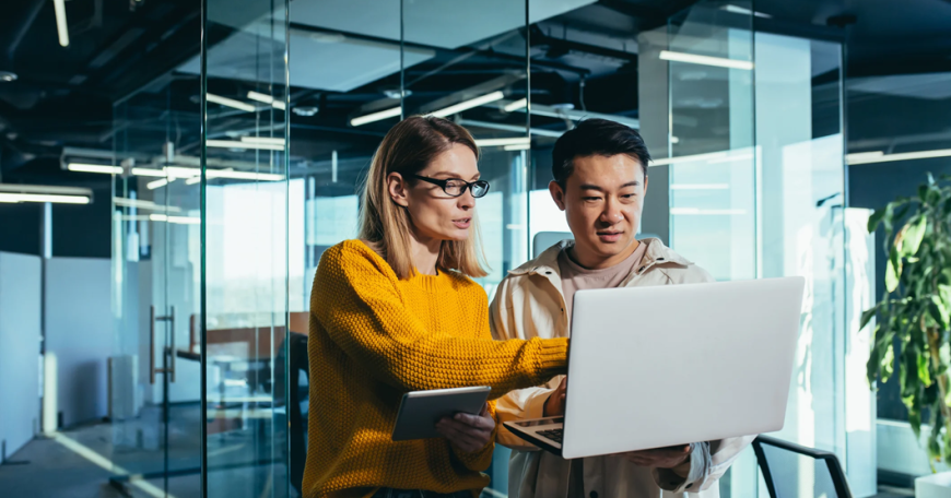 two people looking at a laptop