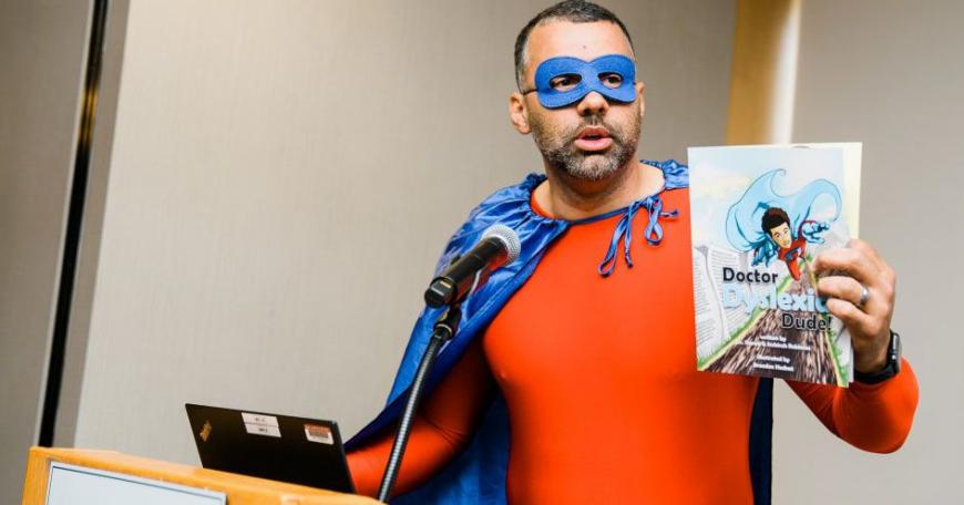 Shawn Robinson, senior research associate at the University of Wisconsin at Madison, helped kick off the first-ever MIT Science of Reading event dressed in full superhero attire as Doctor Dyslexia Dude — the star of a graphic novel series he co-created to engage and encourage young readers, rooted in his own experiences as a student with dyslexia.