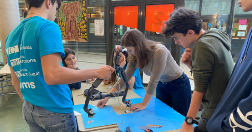 In January 2020, MIT student Irene Terpstra (center, leaning over table) taught a week-long robotics workshop to 11th and 12th graders at CIC Escola de Batxillerats in Barcelona through the GTL Spain Program. 