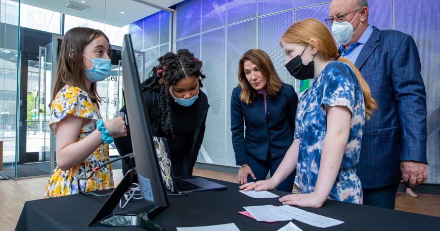 Three students from Mary Lyon School in Boston share their project with Lieutenant Governor Karyn Polito and Vertex Executive Chairman Jeffrey Leiden.