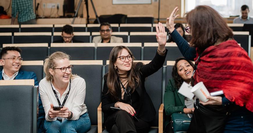 MIT Bootcamps coach Suzanne Mitchell (standing at right) celebrates with learners.