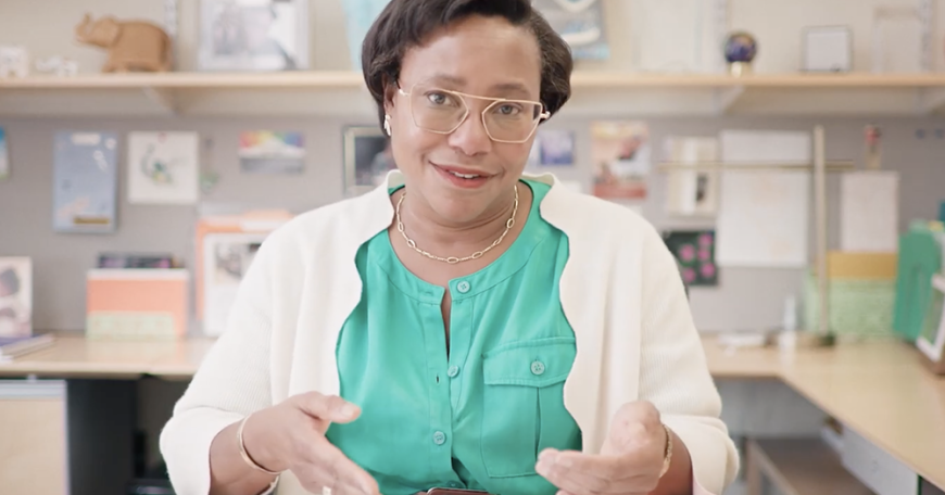 Paula Hammond, seated, speaking to the camera at her desk