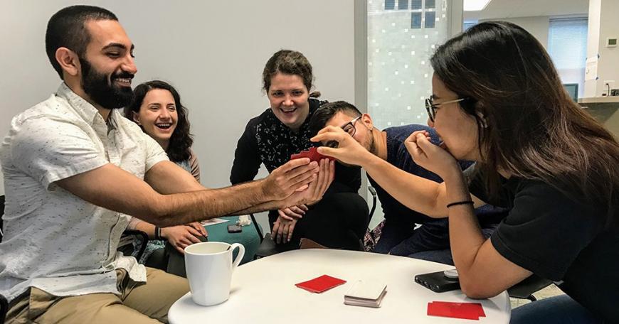 Multi-ethnic group of graduate students playing card game