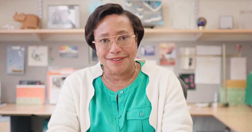 Portrait of Paula Hammond smiling at her desk.