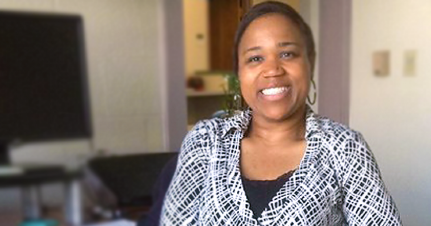 Woman in office setting, smiling at the camera