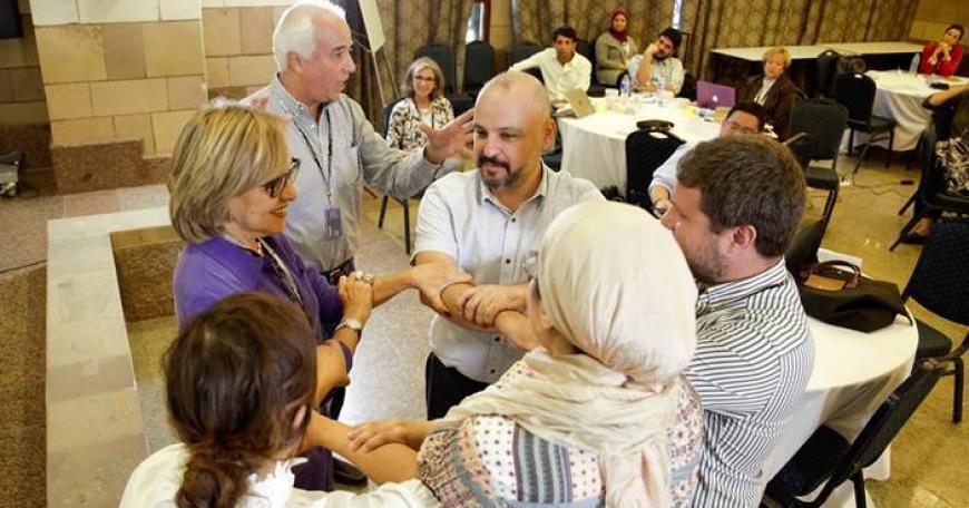 Multi-ethnic group of people standing in a circle, joining hands