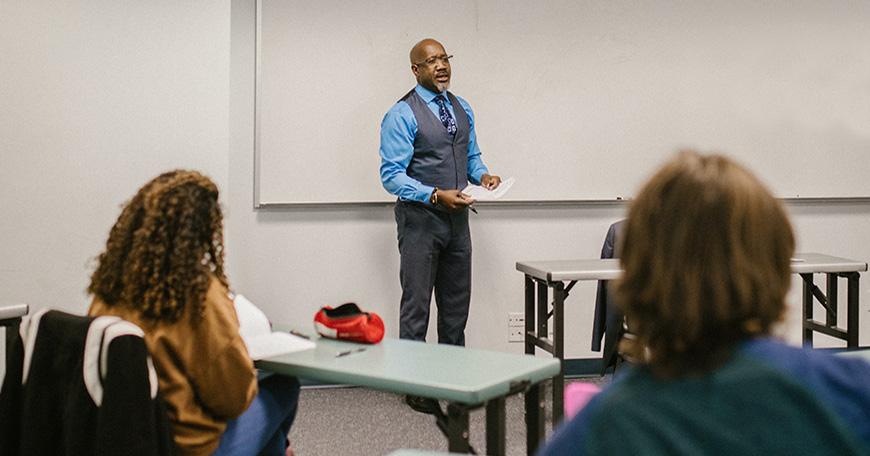 Man in front of classroom (Image Courtesy Rodnae Productions)