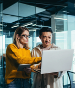 two people looking at a laptop