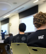 Groups of students in a college lecture hall.