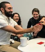 Multi-ethnic group of graduate students playing card game