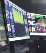 Woman surveys data across several computer screens