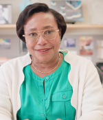 Portrait of Paula Hammond smiling at her desk.