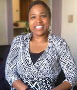 Woman in office setting, smiling at the camera
