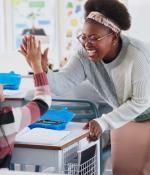 A smiling woman and a child performing a high-five.