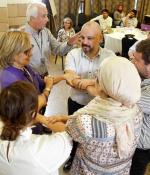 Multi-ethnic group of people standing in a circle, joining hands